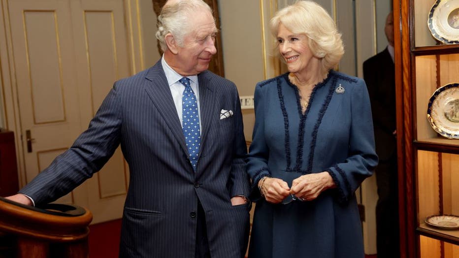 Britain's Camilla, Queen Consort (R) and Britain's King Charles III (L) share a moment at a reception at Clarence House in London on Feb. 23, 2023, for authors, members of the literary community and representatives of literacy charities, to celebrate the second anniversary of The Reading Room. (Photo by CHRIS JACKSON/POOL/AFP via Getty Images)