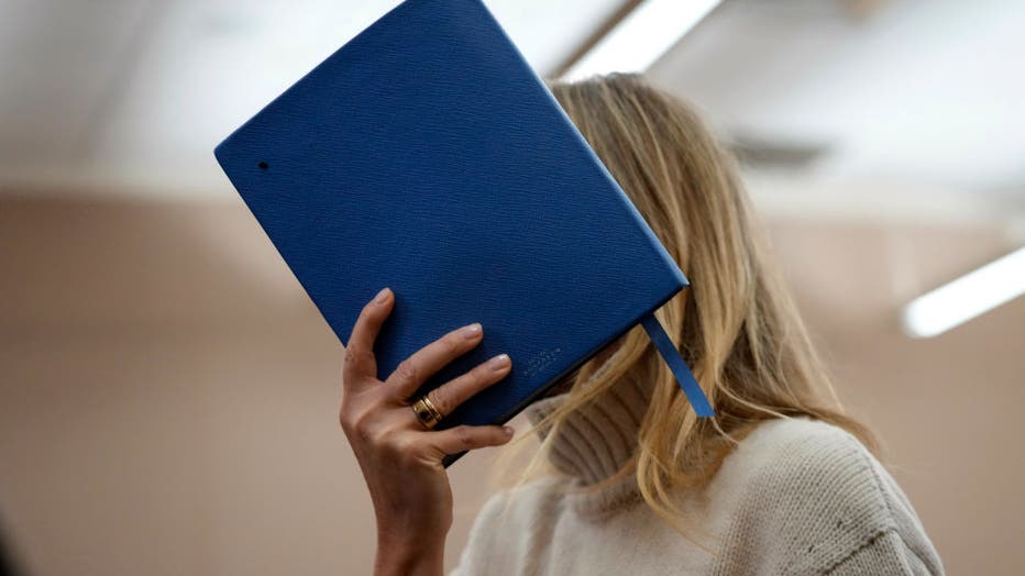 Actress Gwyneth Paltrow shields her face with a blue notebook as she exits a courtroom, where she is accused in a lawsuit of crashing into a skier during a 2016 family ski vacation, leaving him with brain damage and four broken ribs, March 21, 2023, in Park City, Utah. (Photo by Rick Bowmer-Pool/Getty Images)