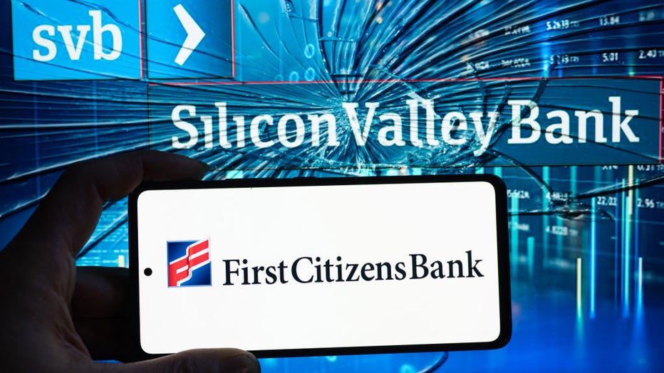 FILE - First Citizens Bank logo displayed on mobile with Silicon Valley Bank seen in the background. (Photo by Jonathan Raa/NurPhoto via Getty Images)
