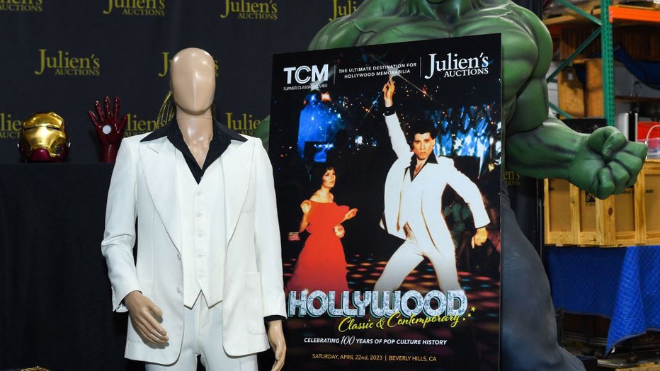 The custom-made white suit worn by John Travolta in "Saturday Night Fever" and an original Hulk figure from the premiere of "The Incredible Hulk" are displayed at Juliens Auctions in Gardena, California, on April 3, 2023. (Photo by VALERIE MACON/AFP via Getty Images)