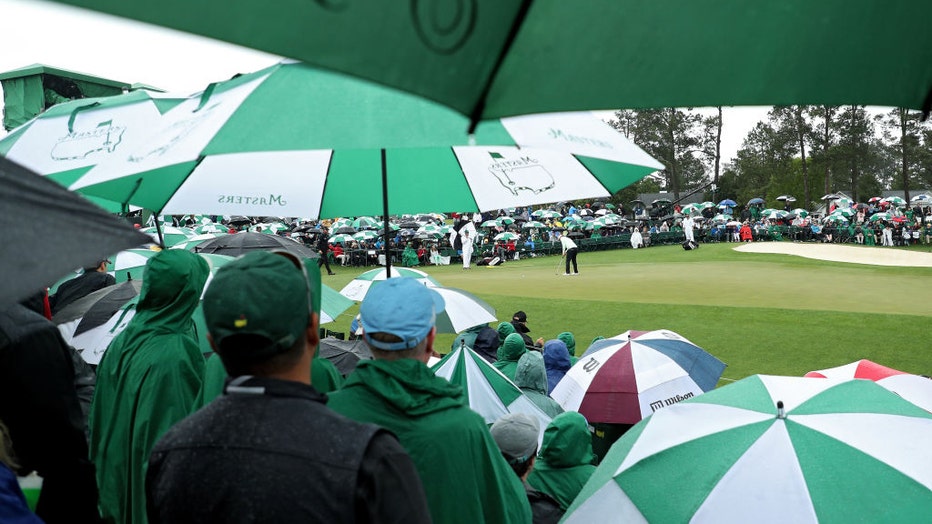 FILE - Fans watch from under umbrellas during the third round of the 2018 Masters Tournament at Augusta National Golf Club on April 7, 2018, in Augusta, Georgia. (Photo by Patrick Smith/Getty Images)