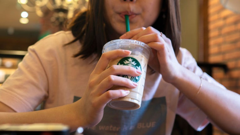 FILE - A girl is seen drinking ice coffee in a Starbucks coffee shop. (Photo by Zhang Peng/LightRocket via Getty Images)