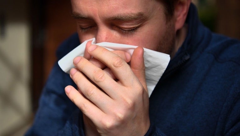 FILE - A man sneezes into a tissue on March 14, 2020. (Photo by Ben Birchall/PA Images via Getty Images)