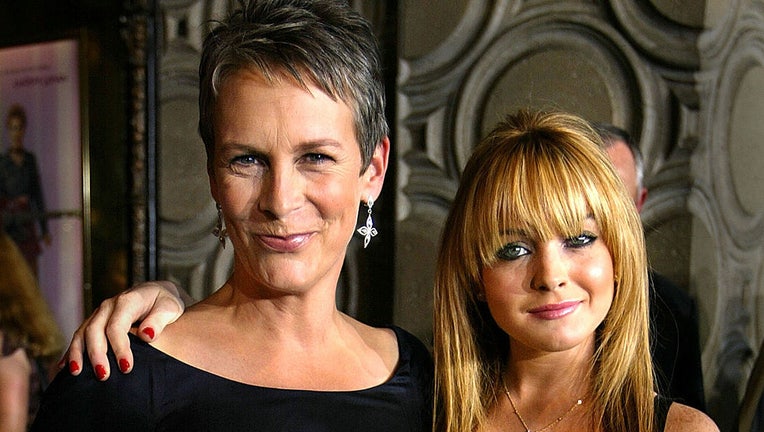 FILE - Actress Jamie Lee Curtis (L) and actress Lindsay Lohan (R), stars of the Disney film "Freaky Friday," pose before the premiere of the movie at the El Capitan theater Aug. 4, 2003, in Hollywood, California. (Photo by Carlo Allegri/Getty Images)