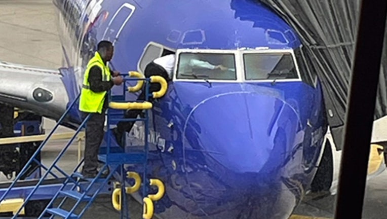 Photos capture Southwest pilot climbing through cockpit window to ...