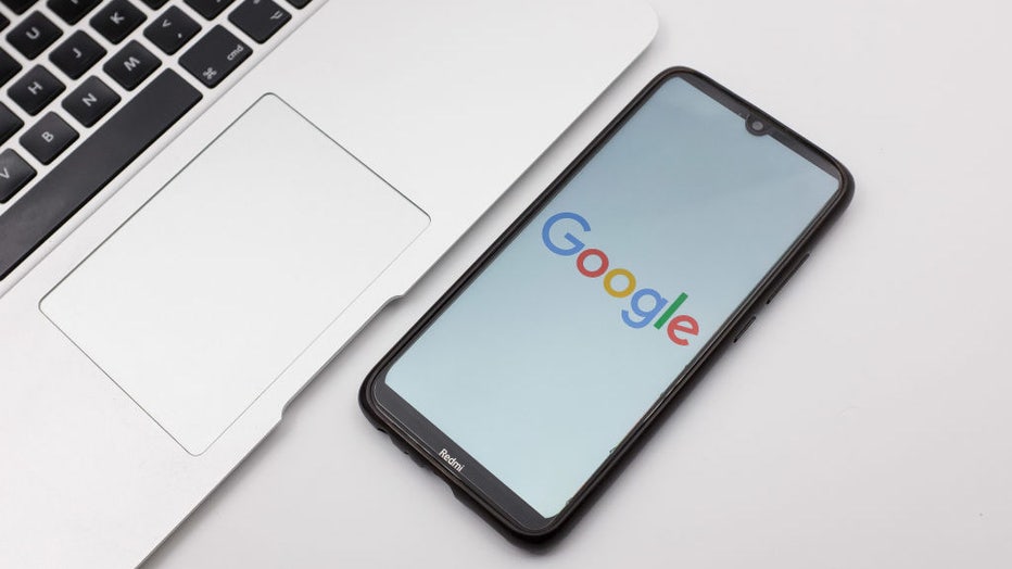 FILE - In this photo illustration a Google logo seen displayed on a smartphone screen on a desk next to a Macbook. (Photo illustration by Nikolas Kokovlis/NurPhoto via Getty Images)