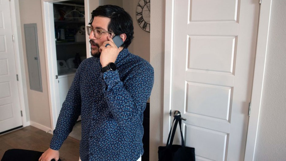FILE IMAGE - Jose Briones speaks to a coworker while using what he refers to as a dumbphone at his apartment in Littleton, Colorado, on March 24, 2023. (Photo by JASON CONNOLLY/AFP via Getty Images)