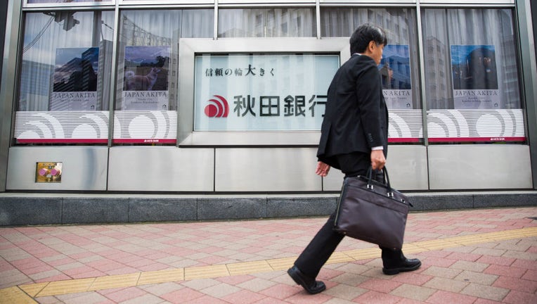 FILE - A man walks past the branch office of a bank in Japan. (Photo by Stanislav Kogiku/SOPA Images/LightRocket via Getty Images)