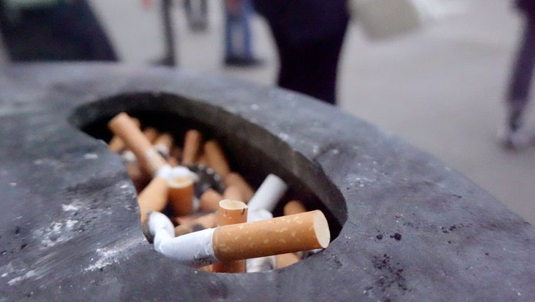 FILE - Cigarette butts sit in an ashtray at a bus stop. (Photo by Marcus Brandt/picture alliance via Getty Images)