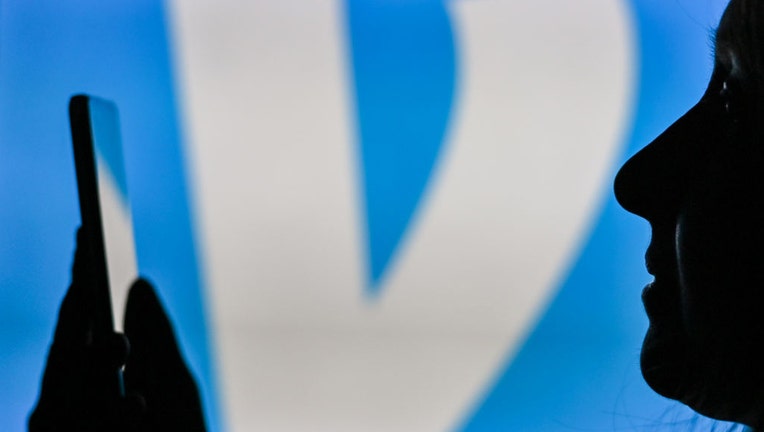 FILE - An image of a woman holding a cell phone in front of the Venmo logo displayed on a computer screen. (Photo by Artur Widak/NurPhoto via Getty Images)