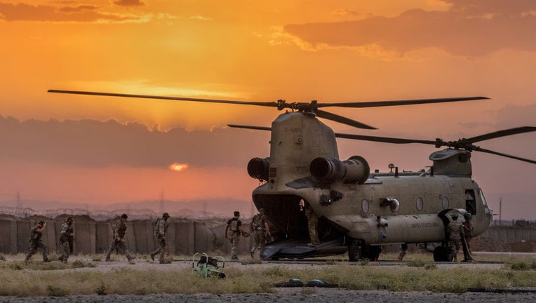 FILE - U.S. Army soldiers board a CH-47 Chinook helicopter while departing a remote combat outpost known as RLZ on May 25, 2021, near the Turkish border in northeastern Syria. (Photo by John Moore/Getty Images)