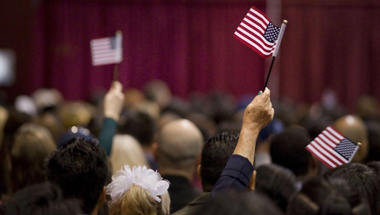 FILE - People wave miniature American flags during a naturalization ceremony in San Diego, California, on March 22, 2017. Photographer: David Maung/Bloomberg via Getty Images