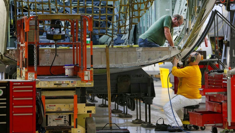 FILE - Aircraft mechanics work on the lift gate on the tail section of a C-130 cargo plane on Dec. 20, 2017 at Hill Air Force base in Ogden, Utah. (Photo by George Frey/Getty Images)