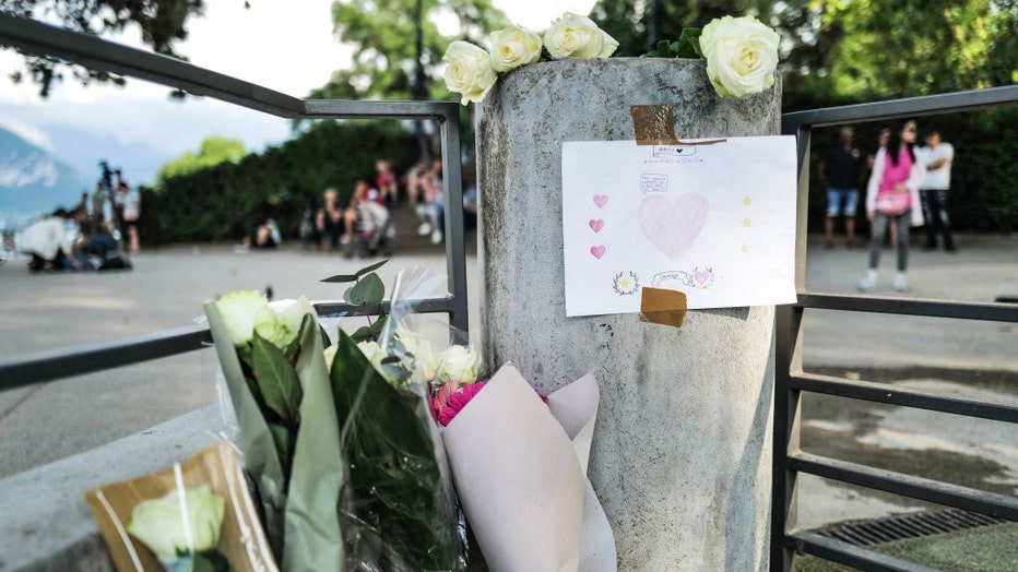 Flowers and a message for the victims are placed at a playground in the 'Jardins de l'Europe' in Annecy, in the French Alps, on June 8, 2023, following a mass stabbing in the park of the city. (Photo by OLIVIER CHASSIGNOLE/AFP via Getty Images)