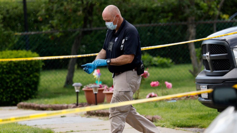 Newton, MA - June 25: An investigator walks out of a home on Broadway Street, where three bodies were discovered. (Photo by Jessica Rinaldi/The Boston Globe via Getty Images)