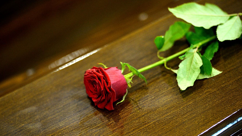 FILE - A rose is displayed on a coffin on Oct. 5, 2013. (Photo credit: ALBERTO PIZZOLI/AFP via Getty Images)