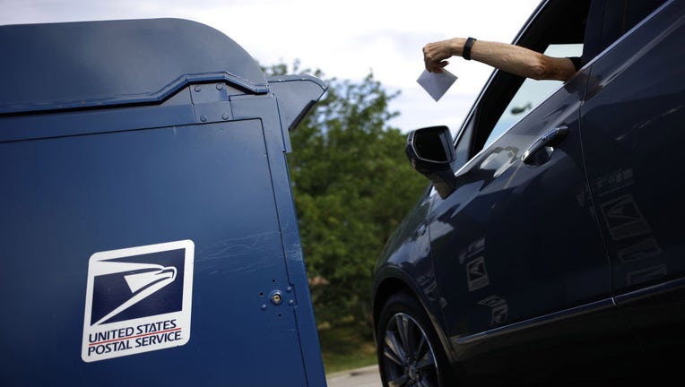 FILE - A driver drops a letter into a United States Postal Service (USPS) mail drop box at a post office in Covington, Kentucky, US, on Saturday, July 2, 2022. Photographer: Luke Sharrett/Bloomberg via Getty Images