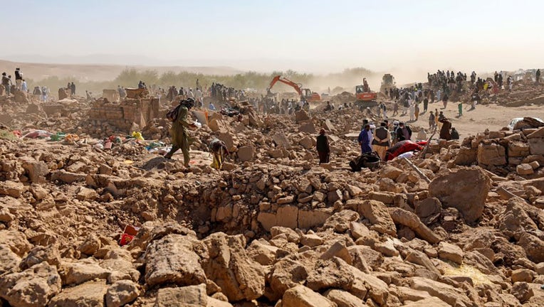 Afghan residents clear debris as they look for victims bodies in the rubble of damaged houses after the earthquakes in Siah Ab village, Zendeh Jan district of Herat province on Oct. 8, 2023. (Photo by MOHSEN KARIMI/AFP via Getty Images)