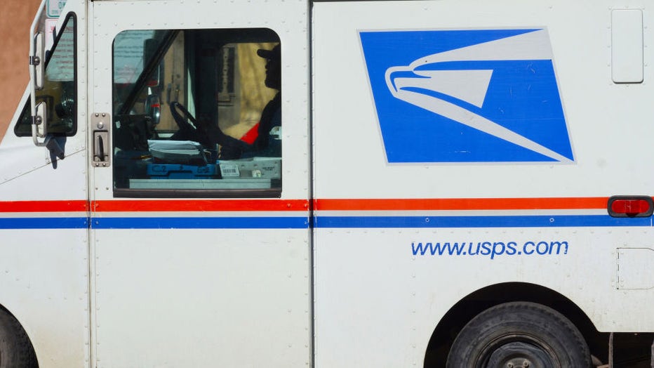 FILE - A U.S. Postal Service mailman driving a Grumman Long Life Vehicle (LLV) delivers mail to businesses in downtown Santa Fe, New Mexico. (Photo by Robert Alexander/Getty Images)