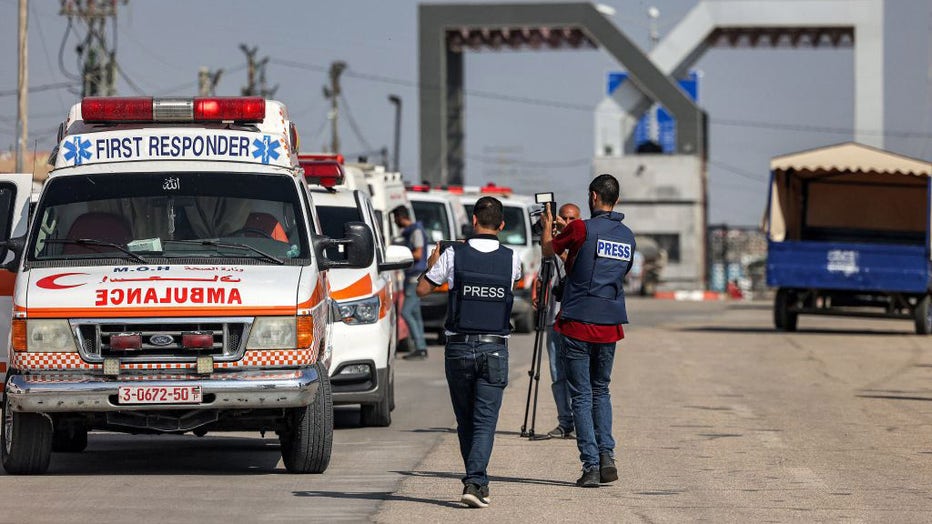 Journalists film as Palestinian health ministry ambulances cross the gate to enter the Rafah border crossing in the southern Gaza Strip before crossing into Egypt on November 1, 2023. (Photo by MOHAMMED ABED/AFP via Getty Images)