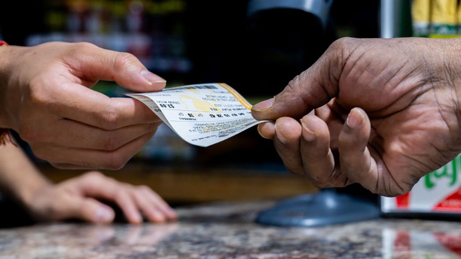 FILE - A customer purchases a Powerball lottery ticket at the Brew Market & Cafe on Oct. 10, 2023, in Austin, Texas. (Photo by Brandon Bell/Getty Images)