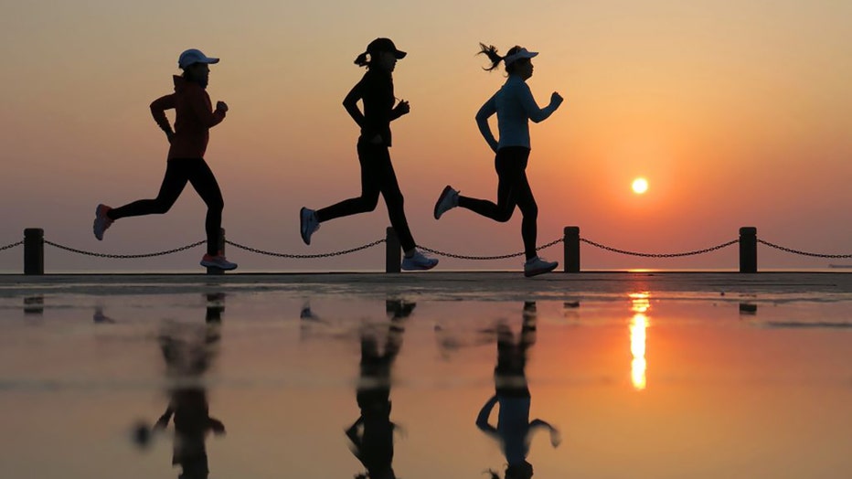 FILE - People run on the beach in Yantai, East Chinas Shandong province, April 9, 2023. (Photo by Costfoto/NurPhoto via Getty Images)