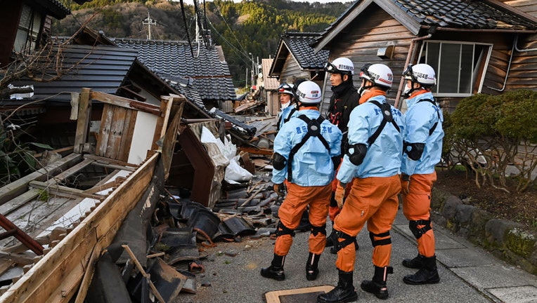 Firefighters inspect collapsed wooden houses in Wajima, Ishikawa prefecture on Jan. 2, 2024, a day after a major 7.5 magnitude earthquake struck the Noto region in Ishikawa prefecture in the afternoon. (Photo by KAZUHIRO NOGI/AFP via Getty Images)