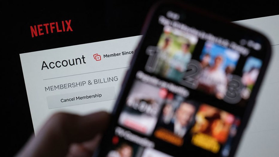 FILE - In this illustration photo taken on July 19, 2022, Netflix show selection is displayed on the screen of a smartphone with the account page in the background in Los Angeles. (Photo by CHRIS DELMAS/AFP via Getty Images)
