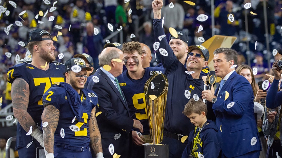 (L-R) Trevor Keegan #77, Blake Corum #2, J.J. McCarthy #9, and Head Football Coach Jim Harbaugh of the Michigan Wolverines celebrate after winning the 2024 CFP National Championship game against the Washington Huskies at NRG Stadium on January 08, 2024 in Houston, Texas. The Michigan Wolverines won the game 34-13. (Photo by Aaron J. Thornton/Getty Images)