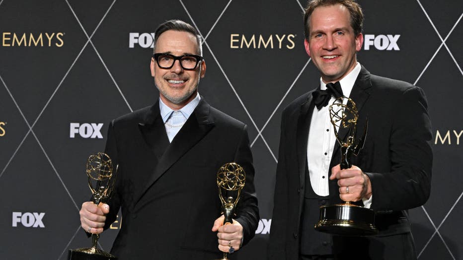 Canadian-British filmmaker David Furnish (L) and Luke Lloyd-Davies pose in the press room with the Outstanding Variety Special (Live) award for "Elton John Live: Farewell from Dodger Stadium" during the 75th Emmy Awards at the Peacock Theatre at L.A. Live in Los Angeles on January 15, 2024. (Photo by ROBYN BECK/AFP via Getty Images)