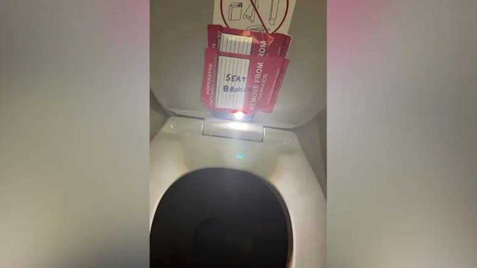 In a photo provided by the law firm Lewis & Llewellyn LLP, an iPhone is taped to the back of a toilet seat on an American Airlines flight from Charlotte, N.C., to Boston, Sept. 2, 2023. (Credit: Provided / Lewis & Llewellyn LLP)