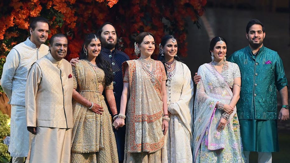 FILE - Indian billionaire Mukesh Ambani (2L) along with his wife Nita (4R) pose with their elder son Akash (R) his wife Shloka (2R), daughter Isha (3R) her husband Anand Piramal (L) and younger son Anant (4L) his fiancée Radhika Merchant (3L) during Anant's engagement ceremony in Mumbai on January 19, 2023. (Photo by Sujit JAISWAL / AFP) (Photo by SUJIT JAISWAL/AFP via Getty Images)