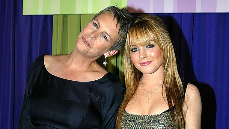 FILE - Actress Jamie Lee Curtis (L) and actress Lindsay Lohan (R), stars of the new Disney film "Freaky Friday," pose as they arrive for the premiere of the movie at the El Capitan theater Aug. 4, 2003, in Hollywood, California. (Photo by Carlo Allegri/Getty Images)