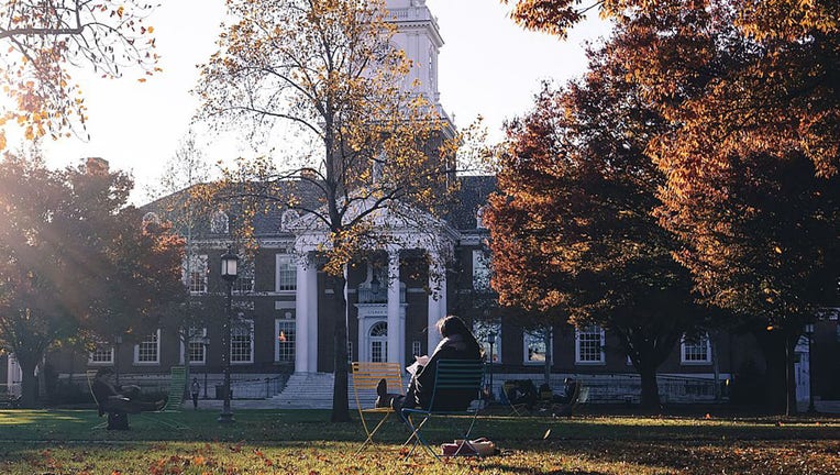 FILE - Students sit on lounge chairs studying in front of Gilman Hall on the leave-covered Keyser quadrangle on the Homewood campus of the Johns Hopkins University in Baltimore, Maryland, in 2015. (Photo by JHU Sheridan Libraries/Gado/Getty Images).