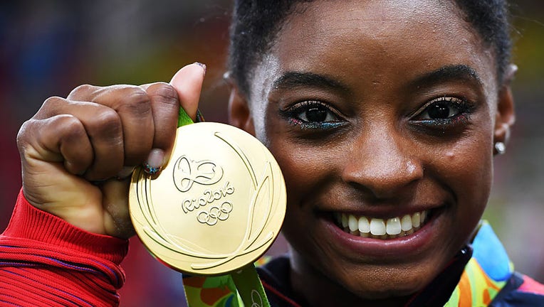 FILE - Simone Biles of the United States poses for photographs with her gold medal after the medal ceremony for the Artistic Gymnastics Womens Team on Day 4 of the Rio 2016 Olympic Games at the Rio Olympic Arena on Aug, 9, 2016, in Rio de Janeiro, Brazil. (Photo by Laurence Griffiths/Getty Images)