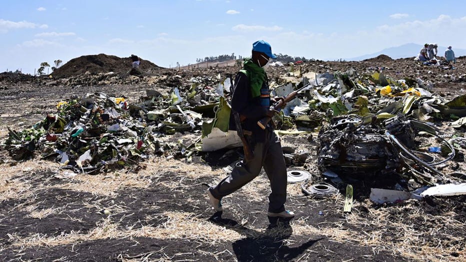 FILE - An Oromo man hired to assist forensic investigators walks by a pile of twisted airplane debris at the crash site of an Ethiopian airways operated Boeing 737 MAX aircraft on March 16, 2019, at Hama Quntushele village near Bishoftu in Oromia region. (Photo credit: TONY KARUMBA/AFP via Getty Images)