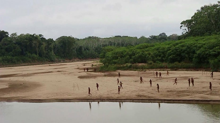 A photo shared by the indigenous rights group Survival International shows dozens of people from the Mashco Piro tribe recently seen on a riverbank near Monte Salvado — a village of the Yine people – in southeast Peru. Credit: Survival International