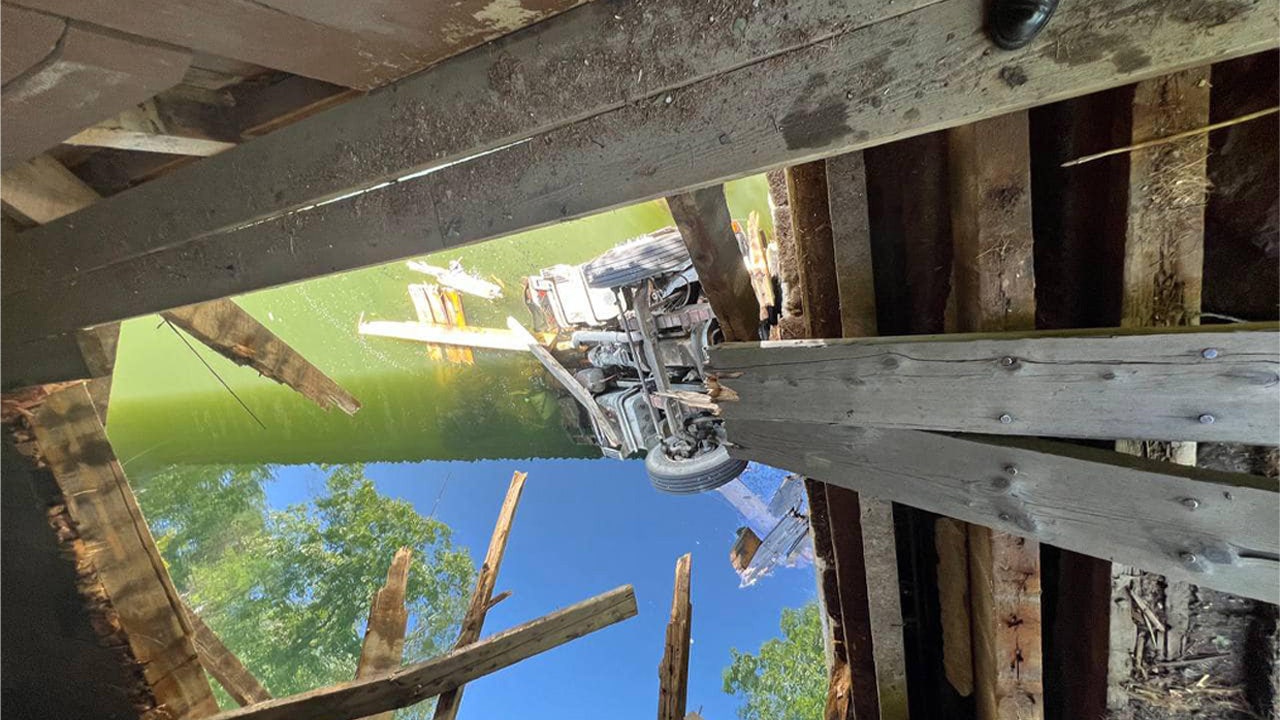 Overweight truck falls through historic covered bridge, plunges