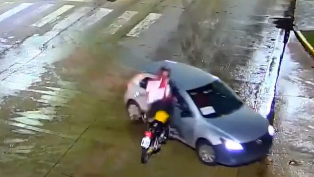 Video shows stunning motorcycle crash with rider flipping over car