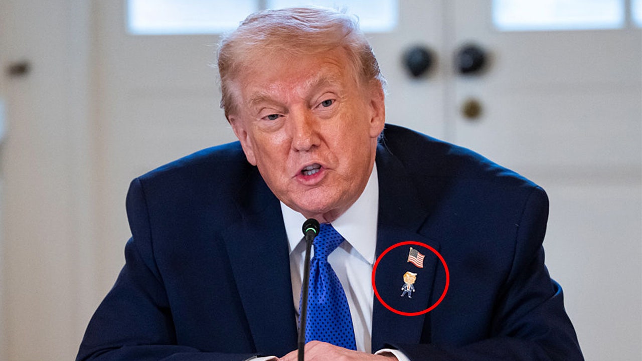 Trump wears 'Happy Trump' pin on lapel, but says he's never happy