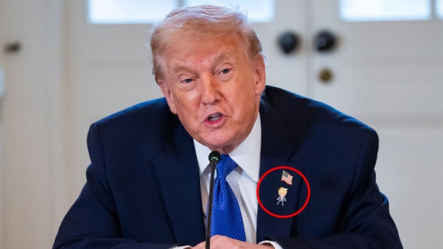 Trump wears 'Happy Trump' pin on lapel, but says he's never happy