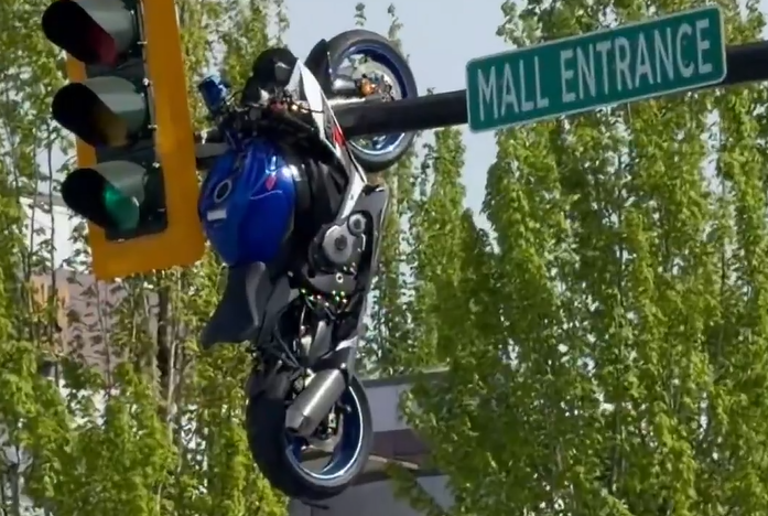 Watch: Motorcycle left dangling from traffic light after crash