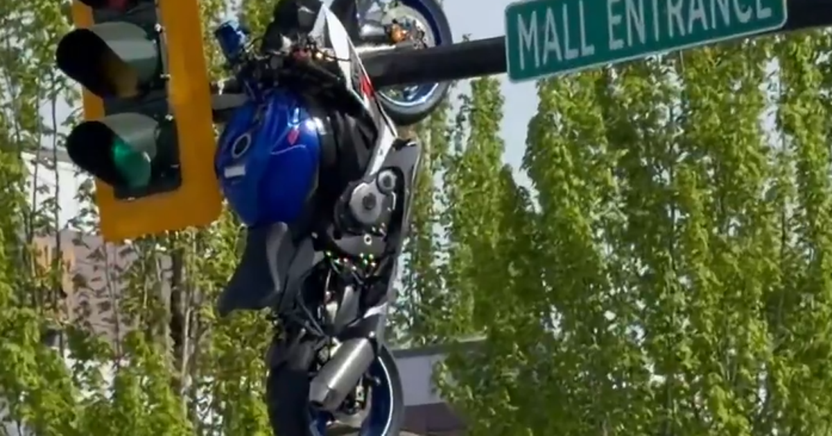 Watch: Motorcycle left dangling from traffic light after crash