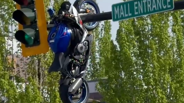 Watch: Motorcycle left dangling from traffic light after crash