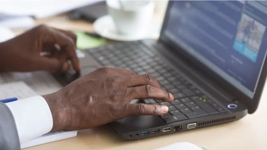 Hands typing on laptop