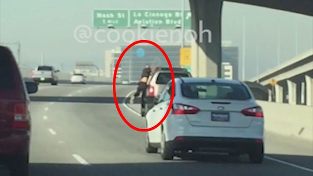 Man holds onto car on 105 Freeway
