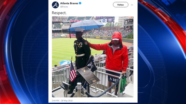 Powerful photo shows Braves fan shielding JROTC member from rain
