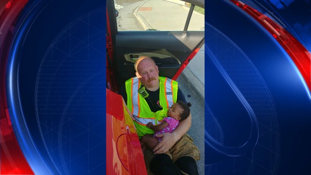 Baby falls asleep in fireman's arms