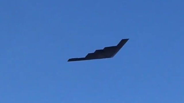 B-2 Spirit flies over cemetery where slain officer was to be laid to rest
