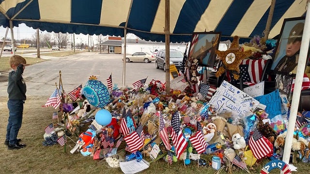 Boy salutes fallen deputy's memorial in touching photo after raising nearly $7K for family